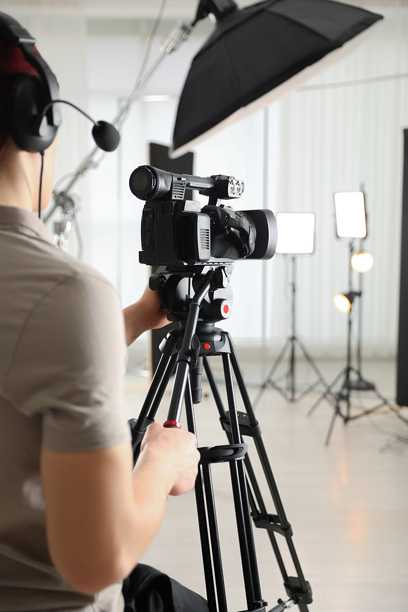 Man with professional video camera in studio, closeup